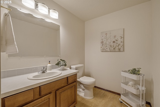 half bath featuring toilet, wood finished floors, and vanity