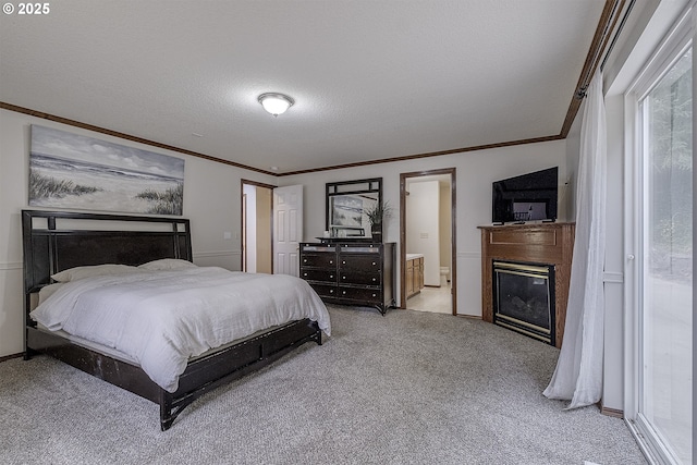 bedroom with light carpet, ornamental molding, a textured ceiling, and a glass covered fireplace