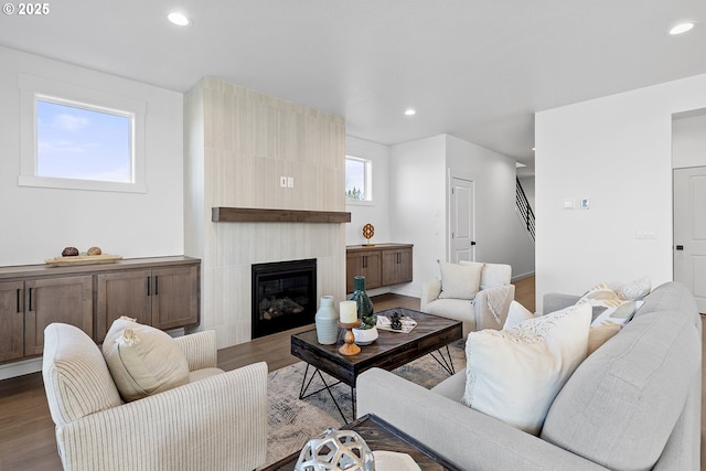 living room with hardwood / wood-style flooring and a tile fireplace