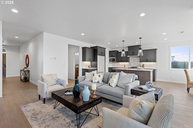 living room with sink and light hardwood / wood-style flooring