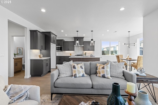 living room with light hardwood / wood-style floors and a chandelier