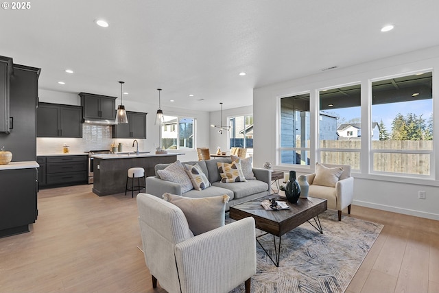 living room featuring sink and light hardwood / wood-style flooring