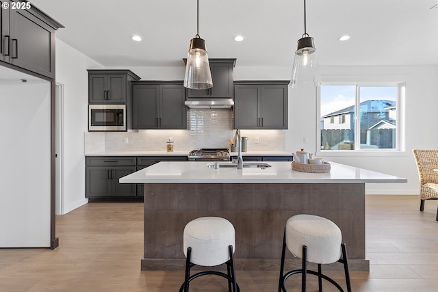 kitchen featuring built in microwave, fridge, sink, and hanging light fixtures