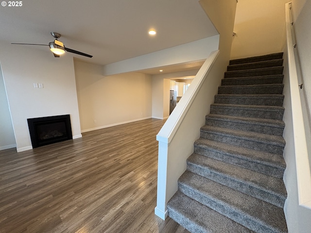 staircase with ceiling fan and hardwood / wood-style flooring