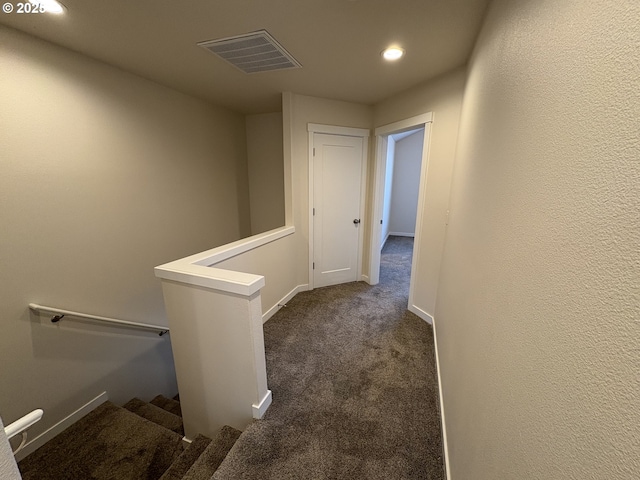 hall featuring dark colored carpet