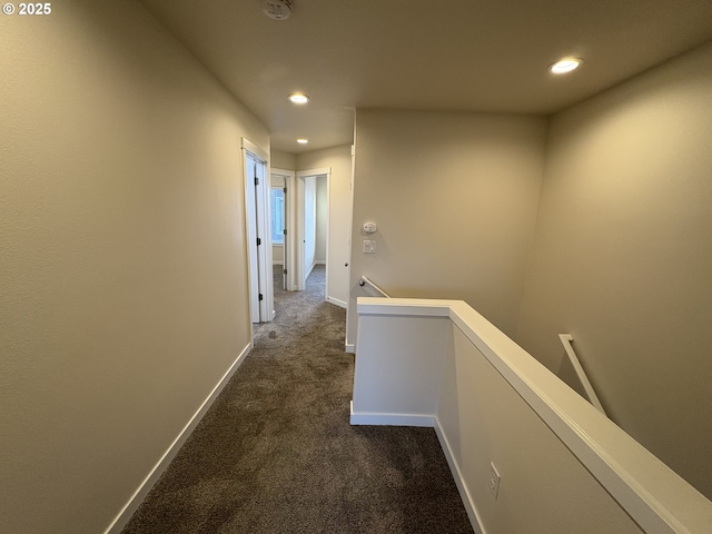 hall with dark colored carpet