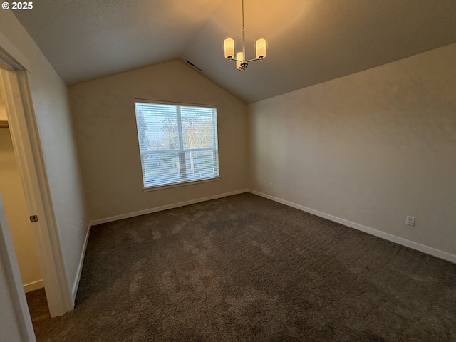 interior space with a chandelier, vaulted ceiling, and dark colored carpet