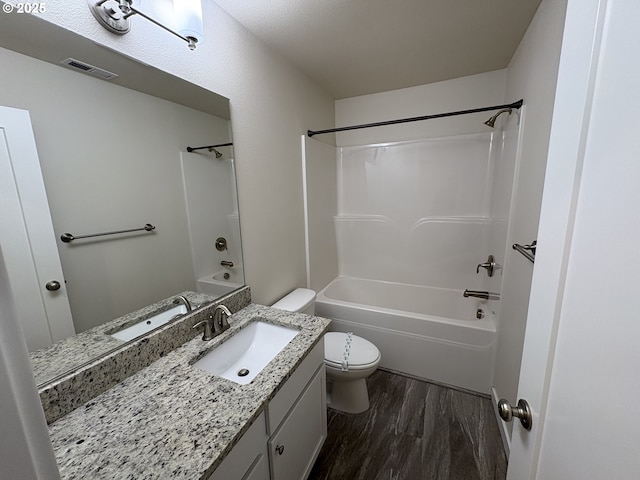 full bathroom with shower / bath combination, vanity, hardwood / wood-style floors, and toilet