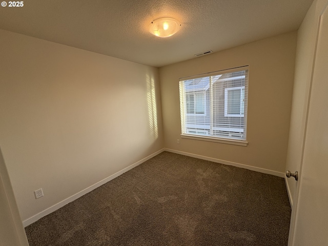 carpeted empty room featuring a textured ceiling