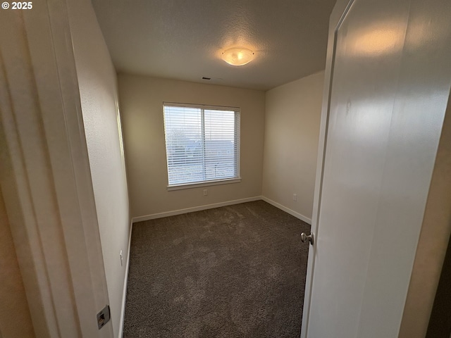 carpeted empty room featuring a textured ceiling