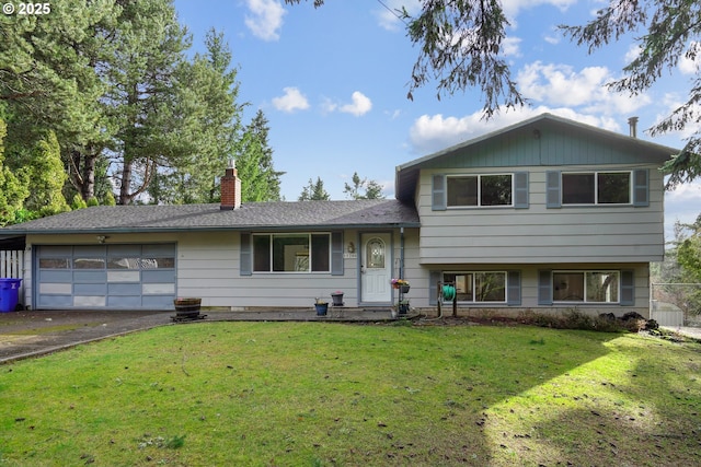 split level home featuring a front lawn, driveway, a chimney, and an attached garage