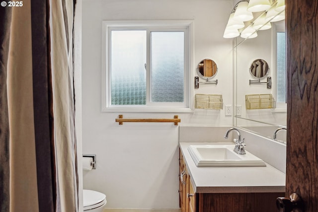 bathroom featuring plenty of natural light, vanity, and toilet