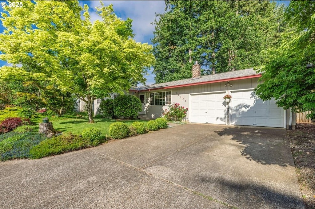 13141 Wassail Ln, Oregon City, OR 97045 - view of front of house featuring a chimney, an attached garage, concrete driveway, and a front lawn