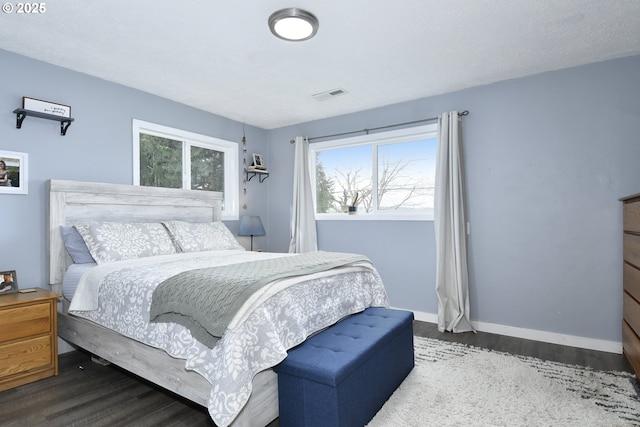 bedroom featuring visible vents, baseboards, and wood finished floors