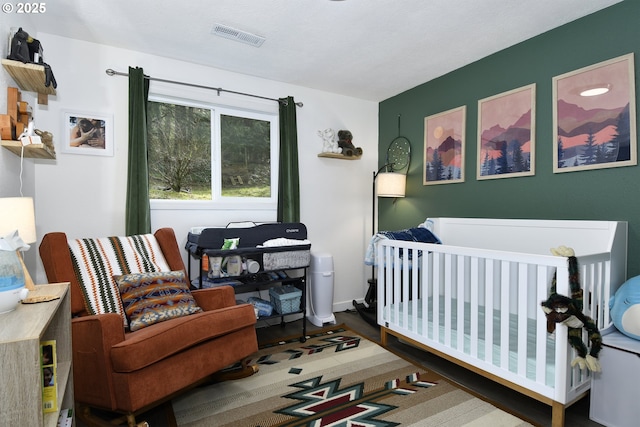 bedroom with visible vents and a crib