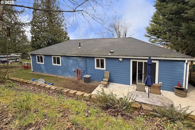 back of property with a patio and a shingled roof