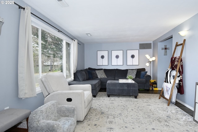 living area featuring baseboards and visible vents