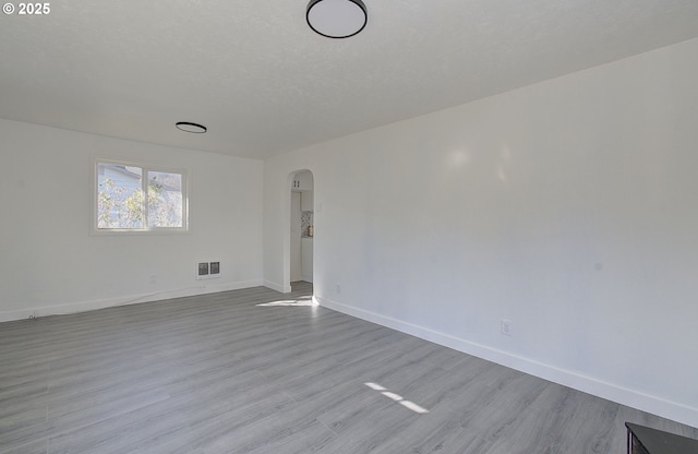 105 Redpath St, Kelso, WA 98626 - spare room with arched walkways, baseboards, and wood finished floors