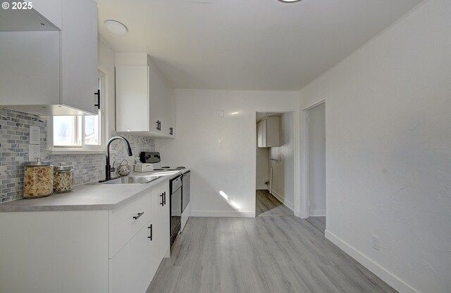 105 Redpath St, Kelso, WA 98626 - kitchen with a sink, decorative backsplash, light wood finished floors, white cabinets, and light countertops