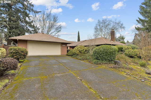 view of home's exterior with driveway, roof with shingles, and an attached garage