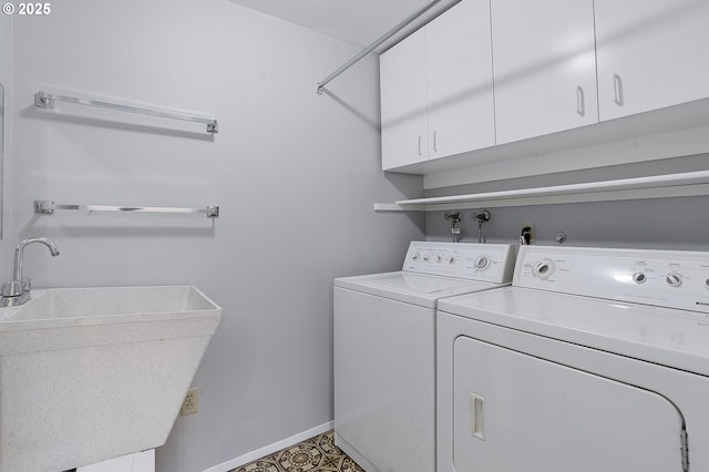 washroom featuring sink, washer and dryer, and cabinets