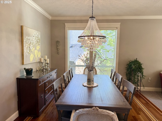 dining space featuring a chandelier, baseboards, a textured ceiling, dark wood finished floors, and ornamental molding