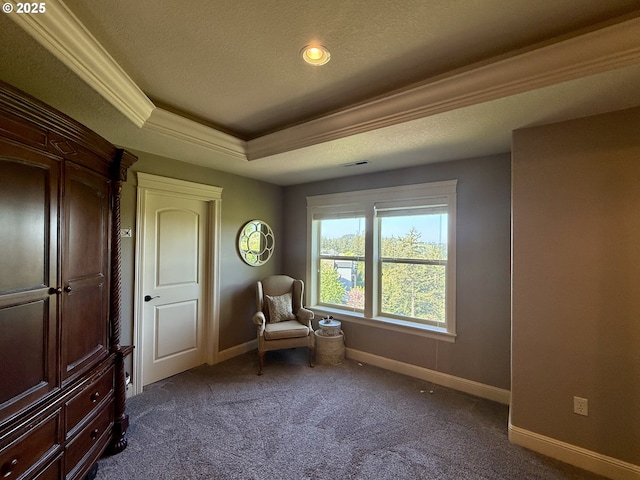 sitting room with dark colored carpet, baseboards, a textured ceiling, a raised ceiling, and ornamental molding