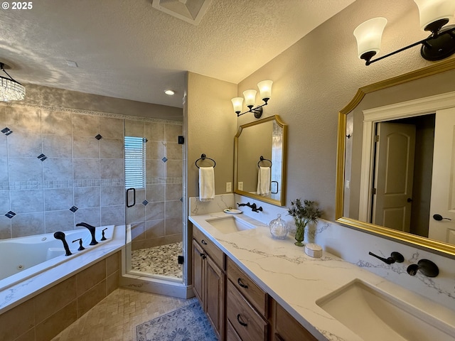 full bathroom featuring a shower stall, a jetted tub, double vanity, and a textured ceiling