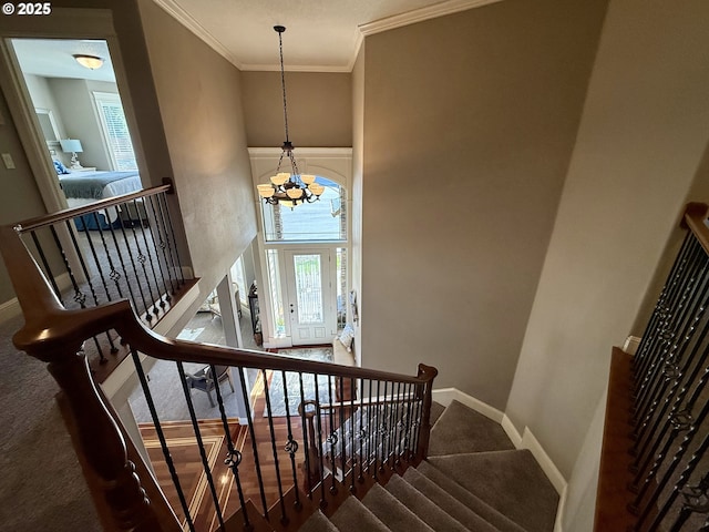 stairway featuring ornamental molding, baseboards, a chandelier, and carpet floors