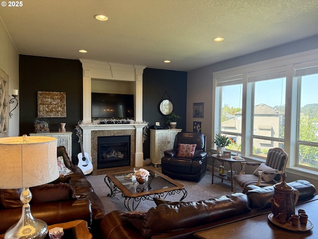 carpeted living room with a glass covered fireplace, recessed lighting, and a textured ceiling
