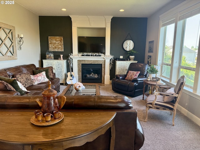 carpeted living room with plenty of natural light, a glass covered fireplace, and recessed lighting