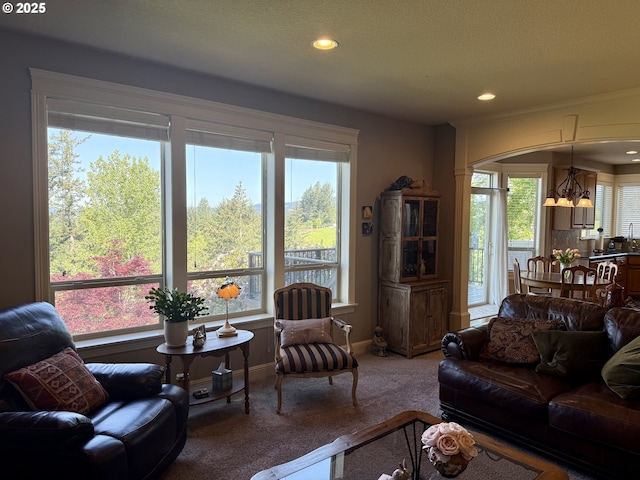 carpeted living area with baseboards, recessed lighting, and a chandelier