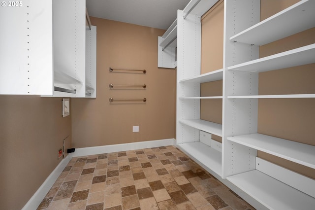 clothes washing area featuring baseboards