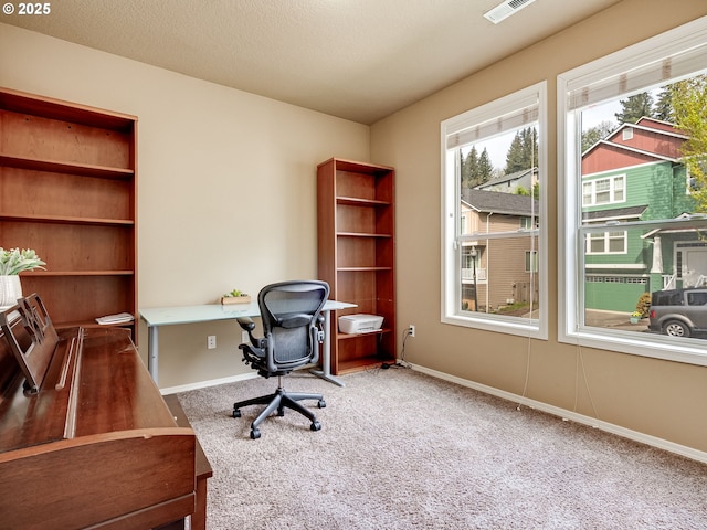 carpeted home office featuring baseboards and visible vents