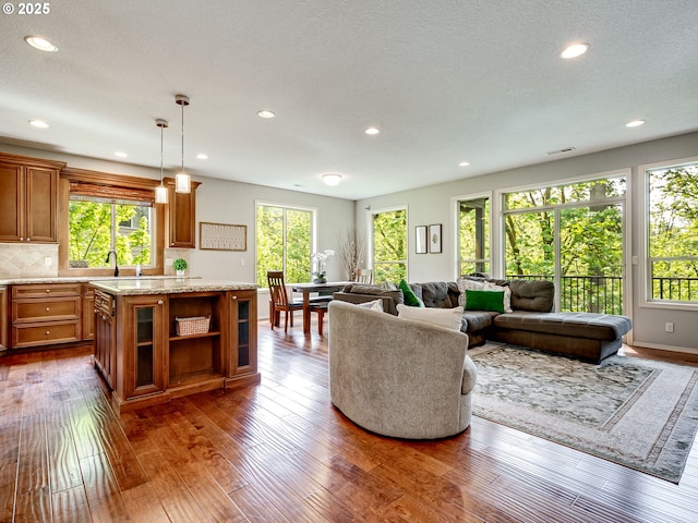 living room featuring dark wood-type flooring, recessed lighting, and a textured ceiling