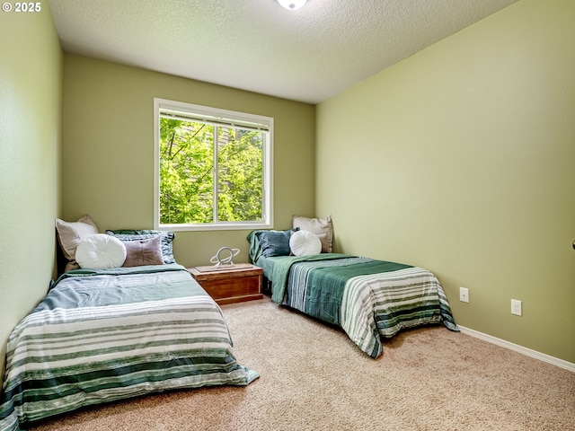 carpeted bedroom featuring baseboards and a textured ceiling