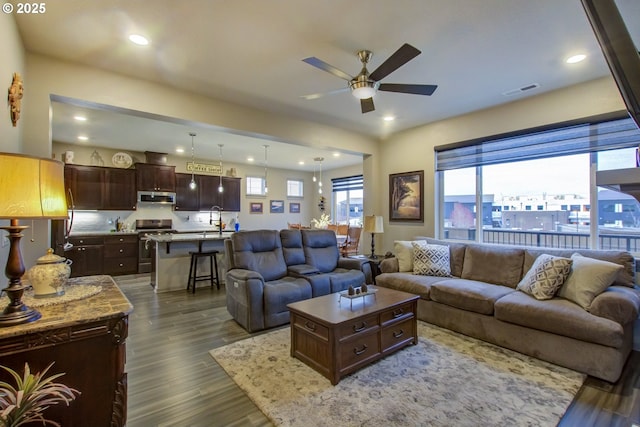 living area featuring recessed lighting, visible vents, dark wood-type flooring, and a ceiling fan