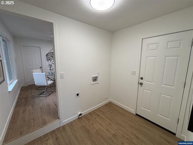 clothes washing area featuring hardwood / wood-style flooring, washer hookup, and electric dryer hookup