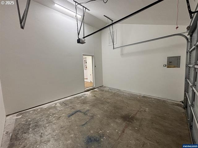 garage with a garage door opener and electric panel