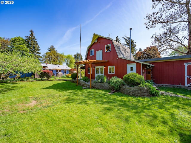 back of property with a lawn, a gambrel roof, and an outbuilding