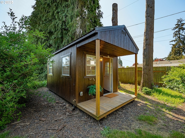 view of outbuilding featuring fence and an outbuilding