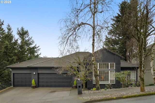 view of front of property with a garage, driveway, and brick siding