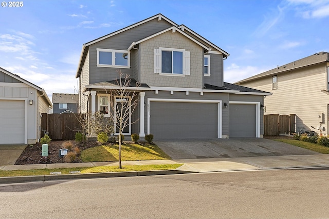 view of front facade with driveway, an attached garage, and fence