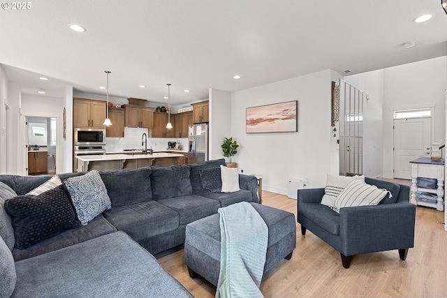 living area with light wood-style floors, recessed lighting, and baseboards