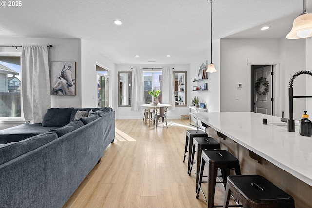 interior space featuring baseboards, a textured ceiling, light wood-type flooring, and recessed lighting