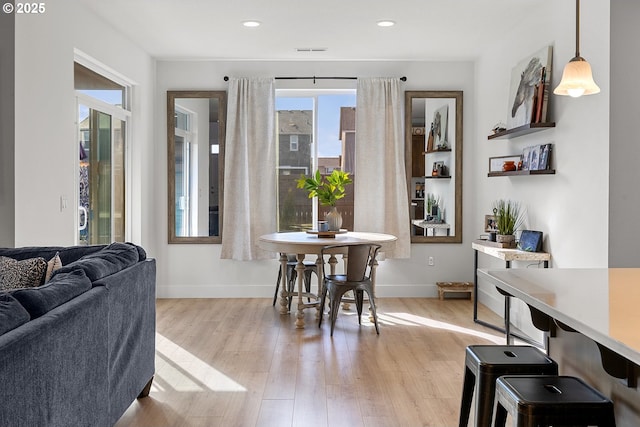 dining space with light wood finished floors, baseboards, visible vents, and recessed lighting