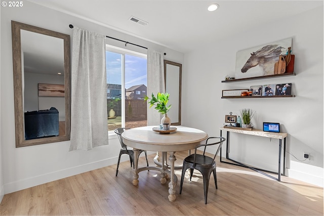 dining area with light wood-style floors, visible vents, and baseboards