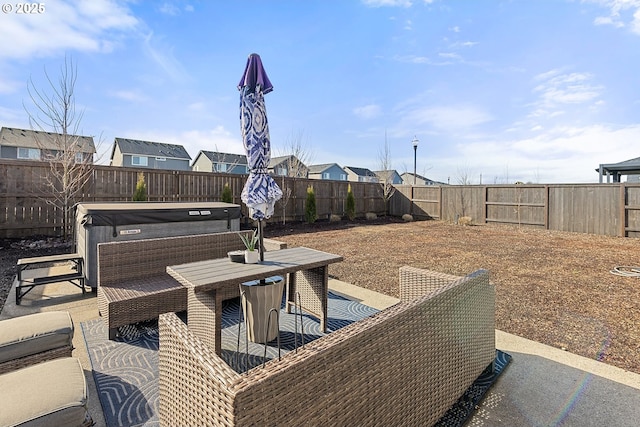 view of patio / terrace with outdoor dining space, a fenced backyard, and a hot tub