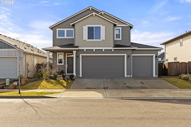 view of front of house with a garage, concrete driveway, and fence