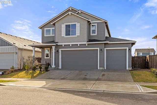 view of front of home featuring an attached garage, fence, and concrete driveway